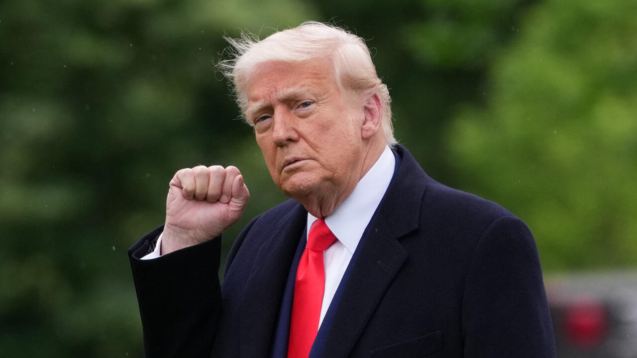President Donald Trump raises a fist while wearing a red tie, amid reports Wall Street now calls him “TACO” for backing down on tariffs