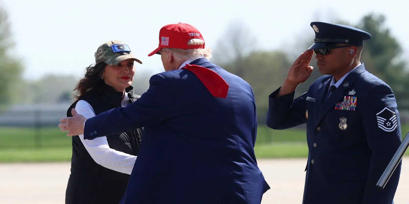 President Trump greets Michigan Governor Gretchen Whitmer while a military officer salutes, amid controversial pardon comments