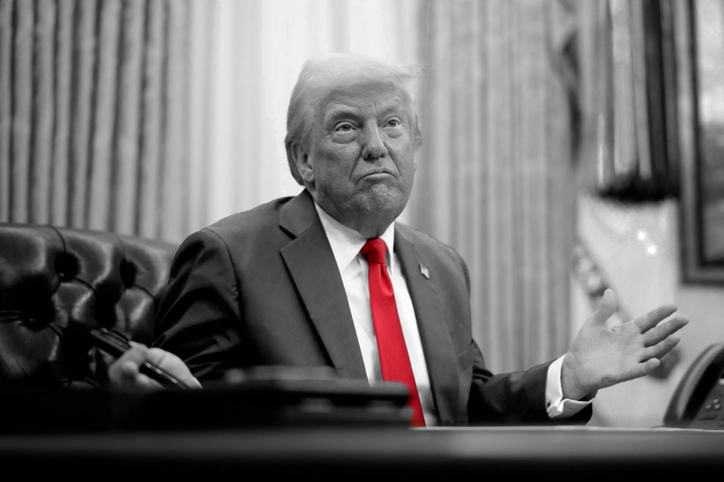 Donald Trump at the Resolute Desk with a confused expression, in black and white except for his red tie
