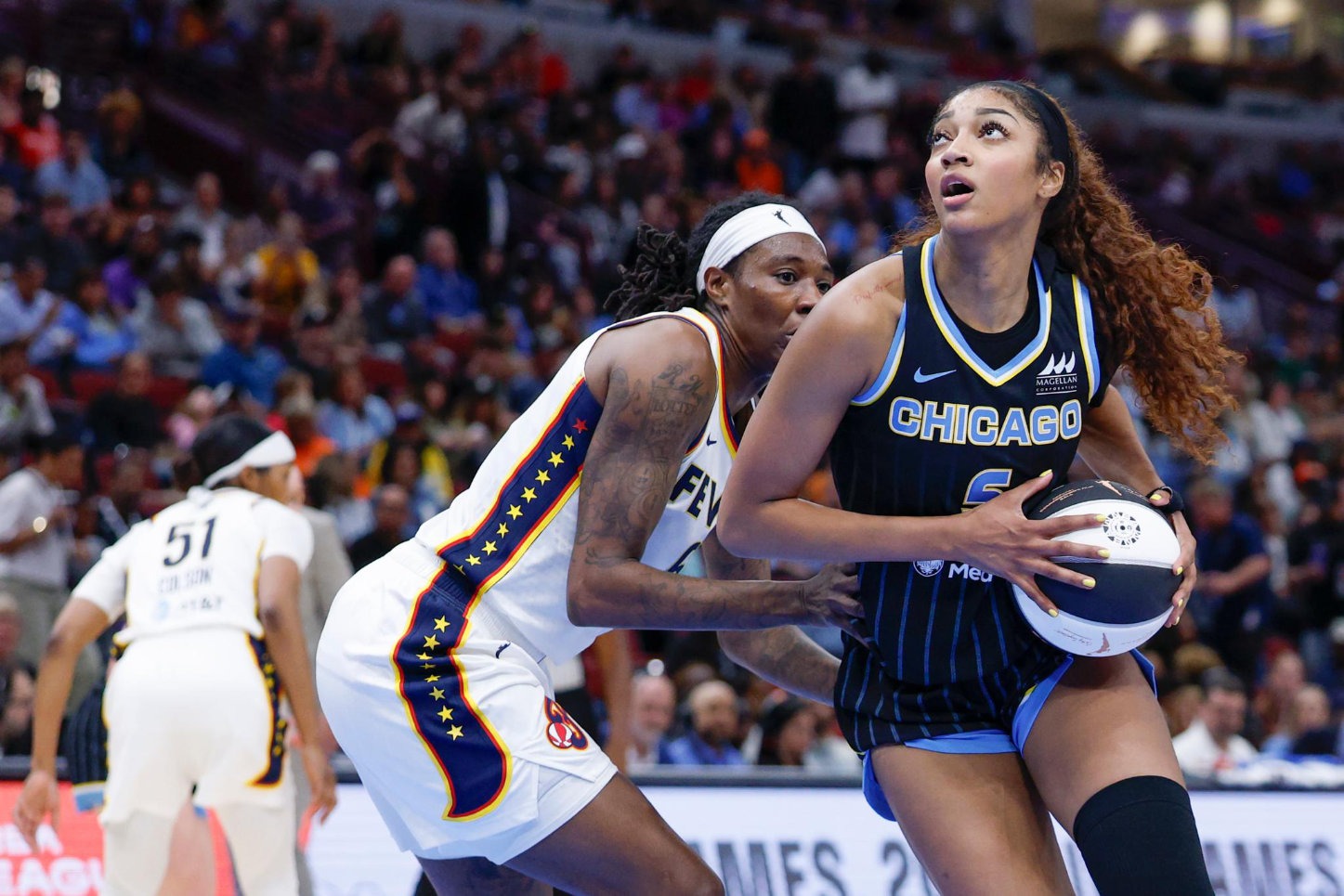 Chicago Sky forward Angel Reese holds the ball while being defended by an Indiana Fever player during a WNBA game