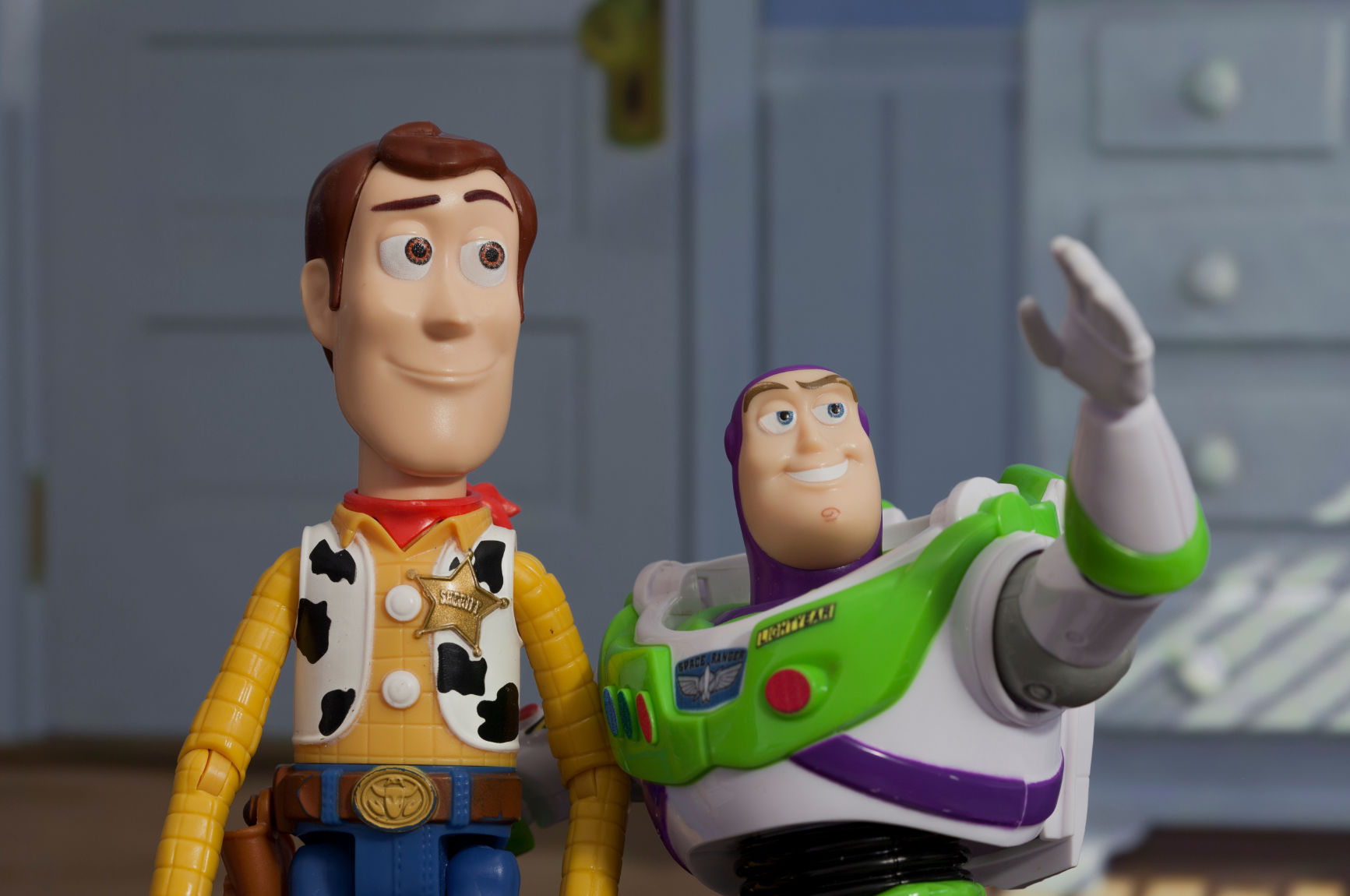 Woody and Buzz Lightyear from Toy Story standing together in a child’s bedroom