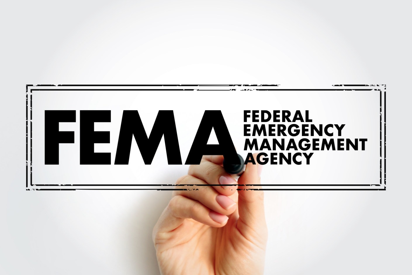 Hand underlining the FEMA logo, which stands for Federal Emergency Management Agency