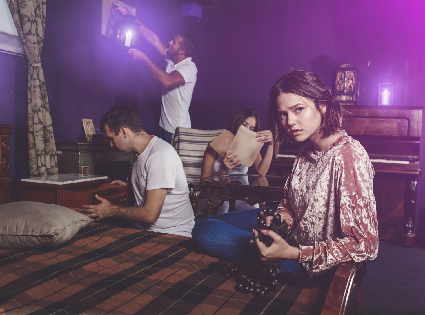 Friends looking at wooden rosary in escape room