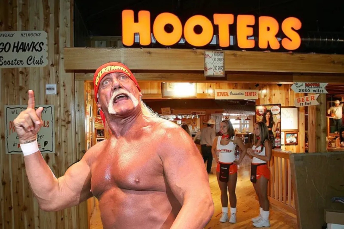 Hulk Hogan poses shirtless in front of a Hooters restaurant while flexing, with two Hooters waitresses in uniform standing in the background