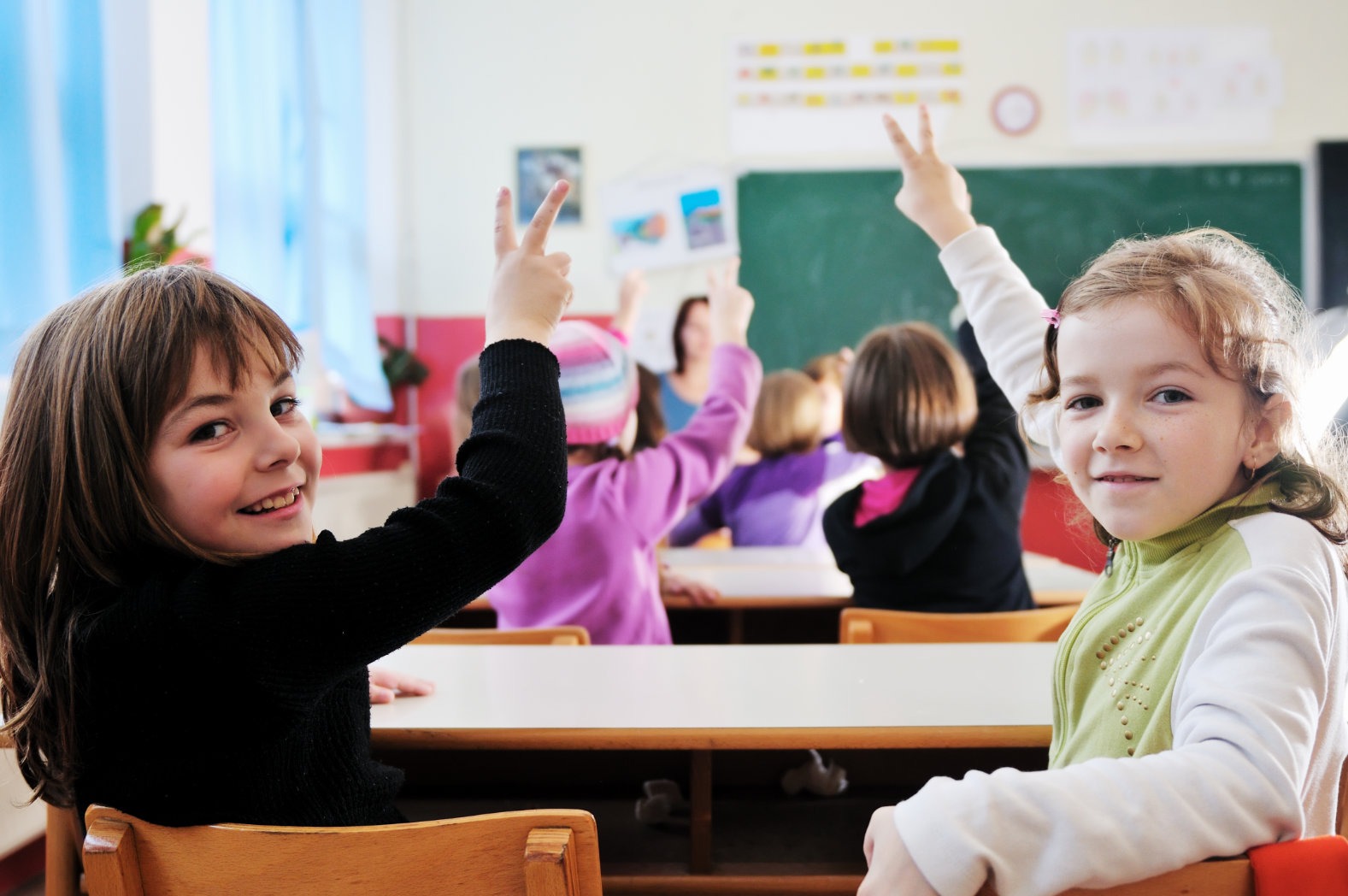 Teacher with textbook in front of confused students in classroom