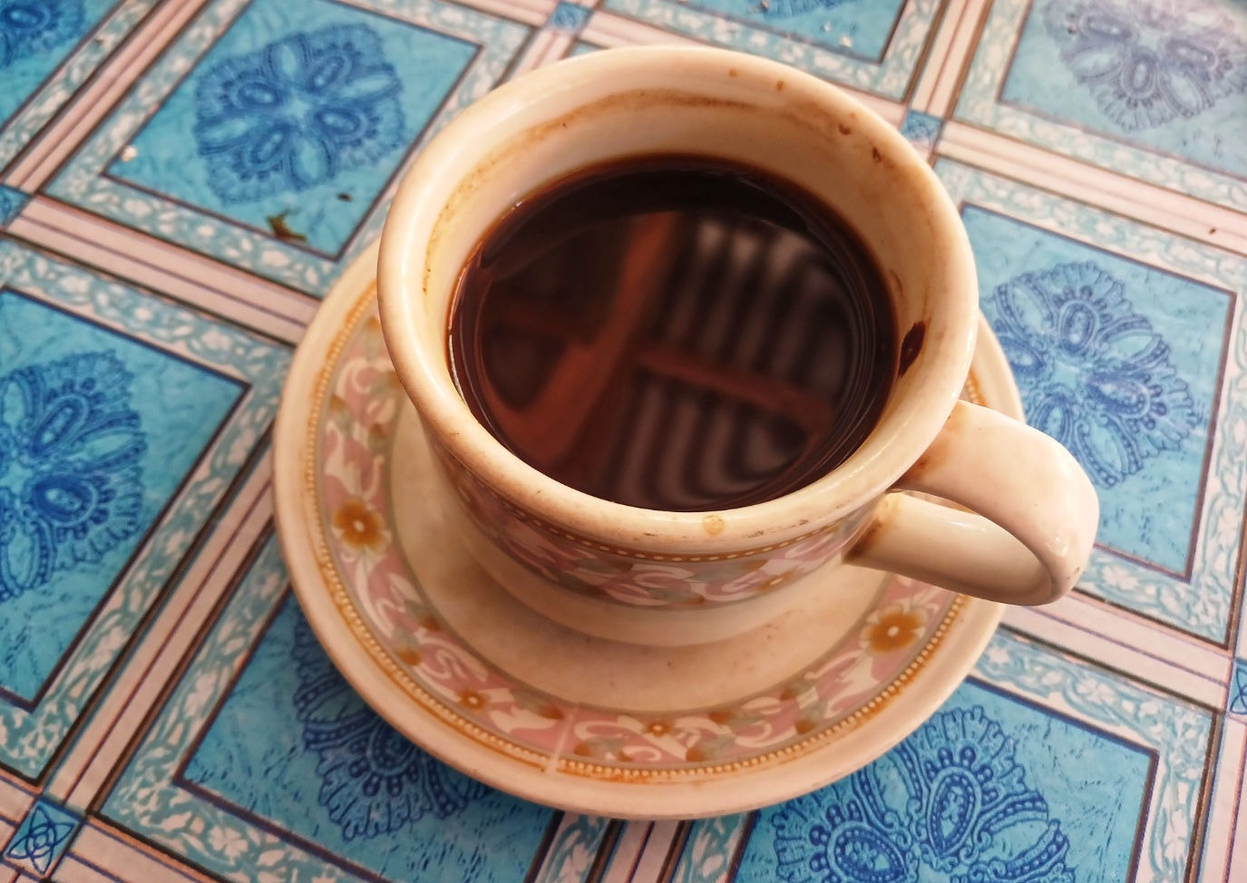 Cup of coffee isolated on blue checkered tablecloth background. Cup of coffee