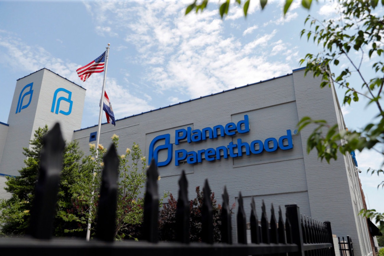 Protesters holding signs in support of Planned Parenthood outside a government building