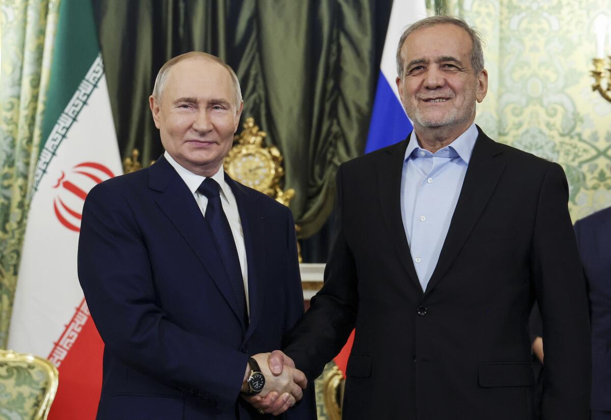 Vladimir Putin shakes hands with Iranian President Masoud Pezeshkian during meeting
