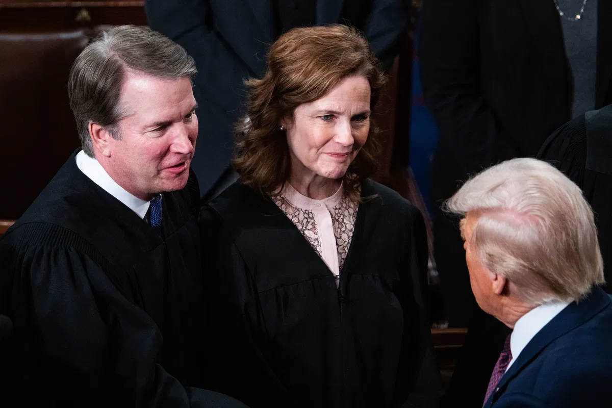 Donald Trump speaking to Supreme Court Justices Amy Coney Barrett and Brett Kavanaugh during a formal event