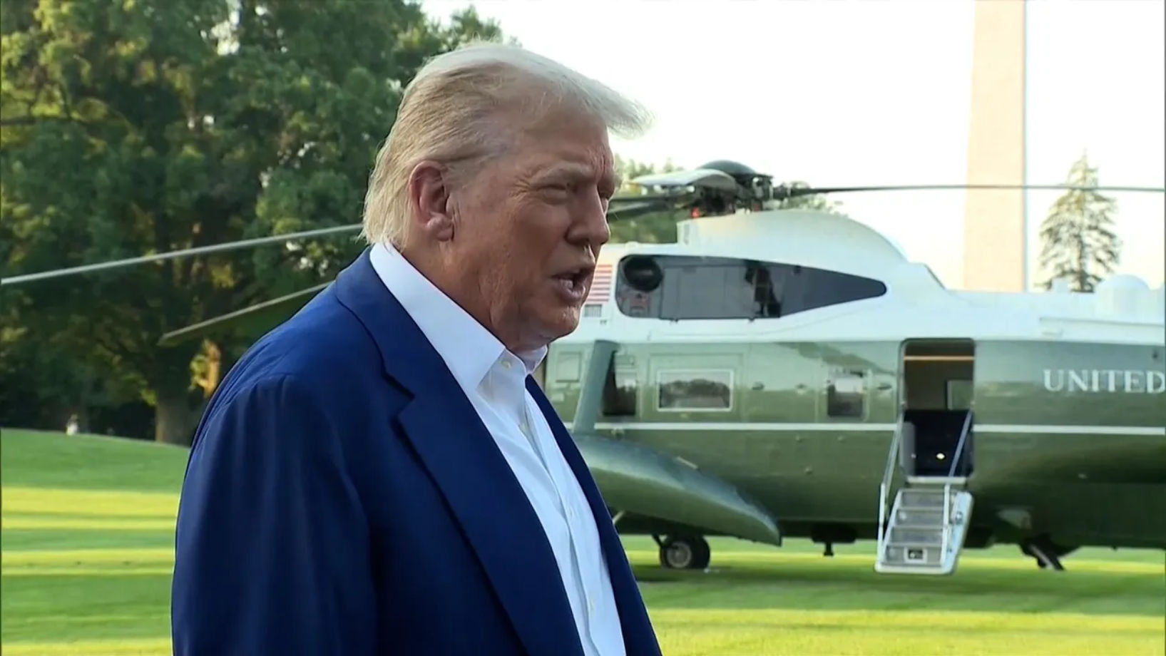 Donald Trump speaking outdoors in front of multiple microphones
