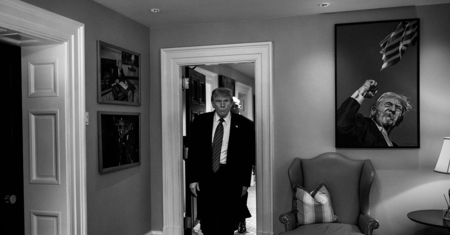 Black and white photo of trump entering a room.