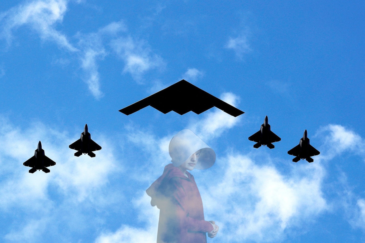 A B2 stealth bomber flies overhead accompanied by fighter jets.