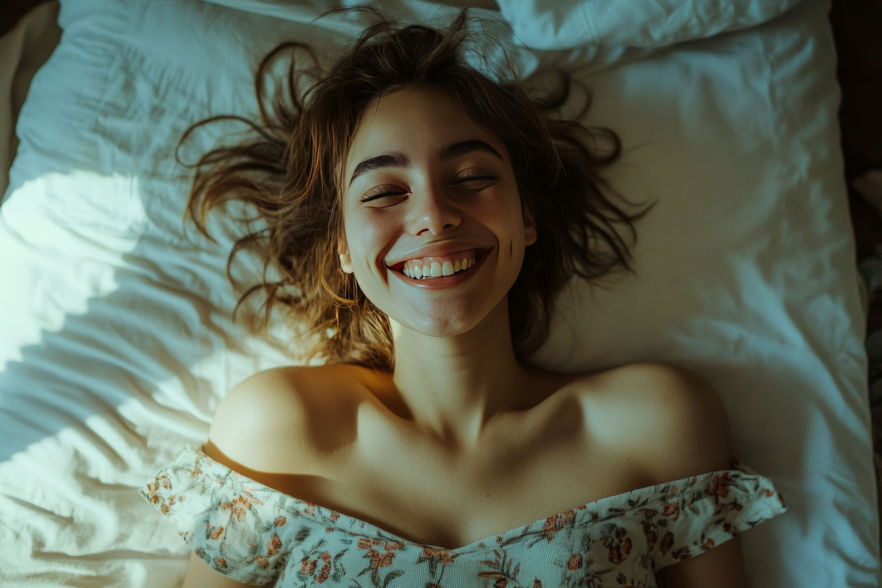 Smiling young woman lying on bed enjoying morning light and comfort