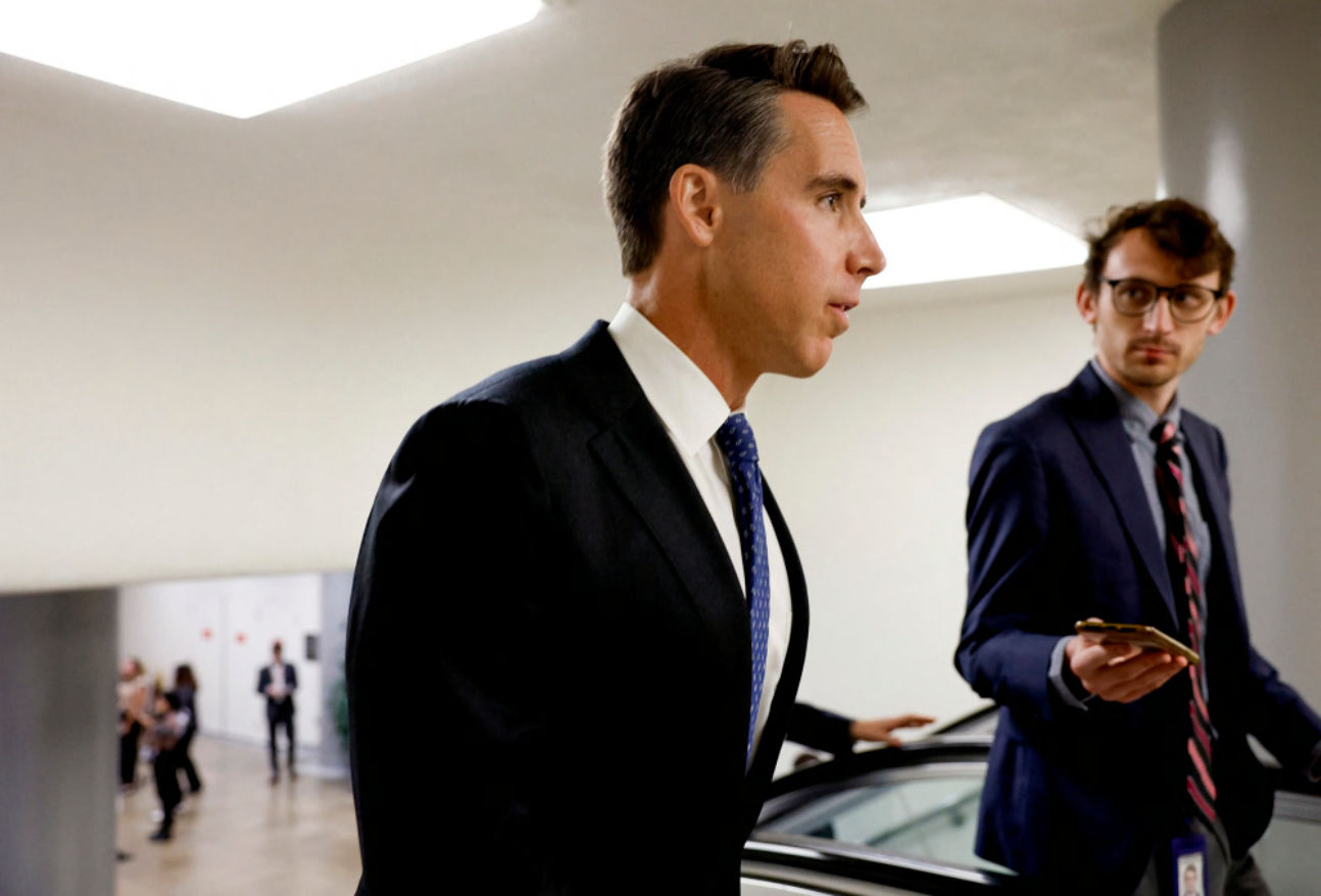 Senator Josh Hawley speaking to a reporter in a government hallway