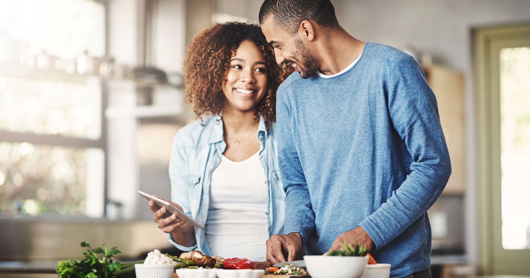 Couple smiling with a grocery cart full of store-brand goods