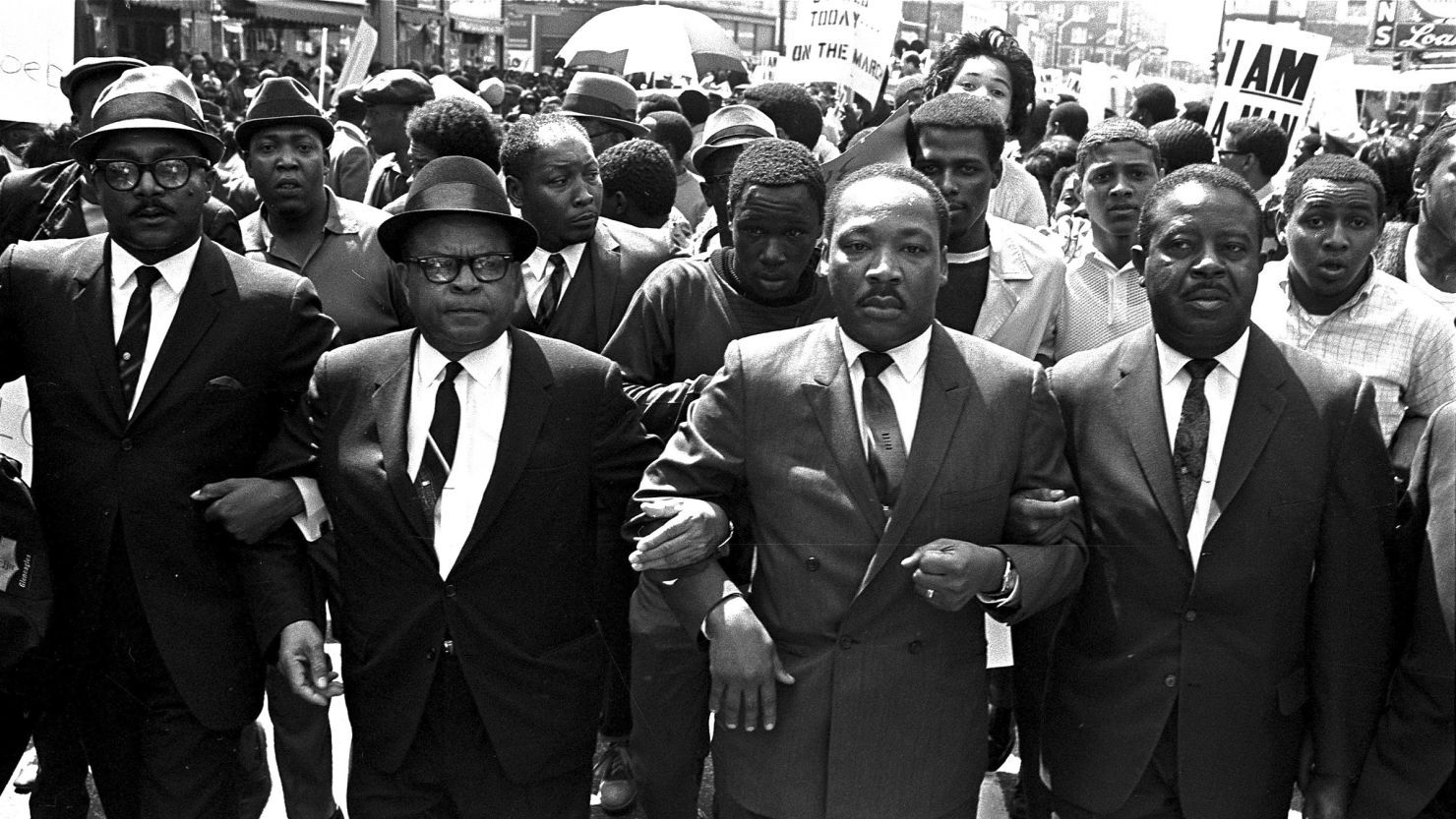 Martin Luther King Jr. marches arm-in-arm during the civil rights movement