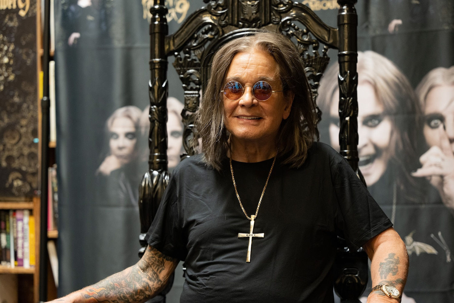 Ozzy Osbourne smiling in sunglasses and black shirt on gothic throne