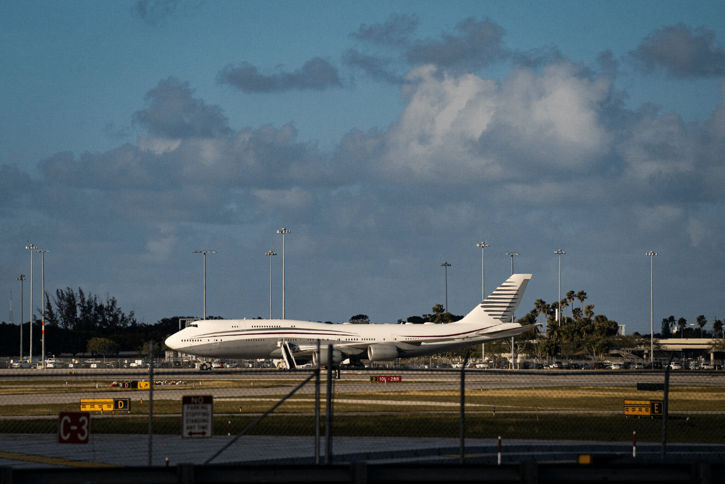 Donald Trump waving next to used Qatari Boeing jet intended as Air Force One
