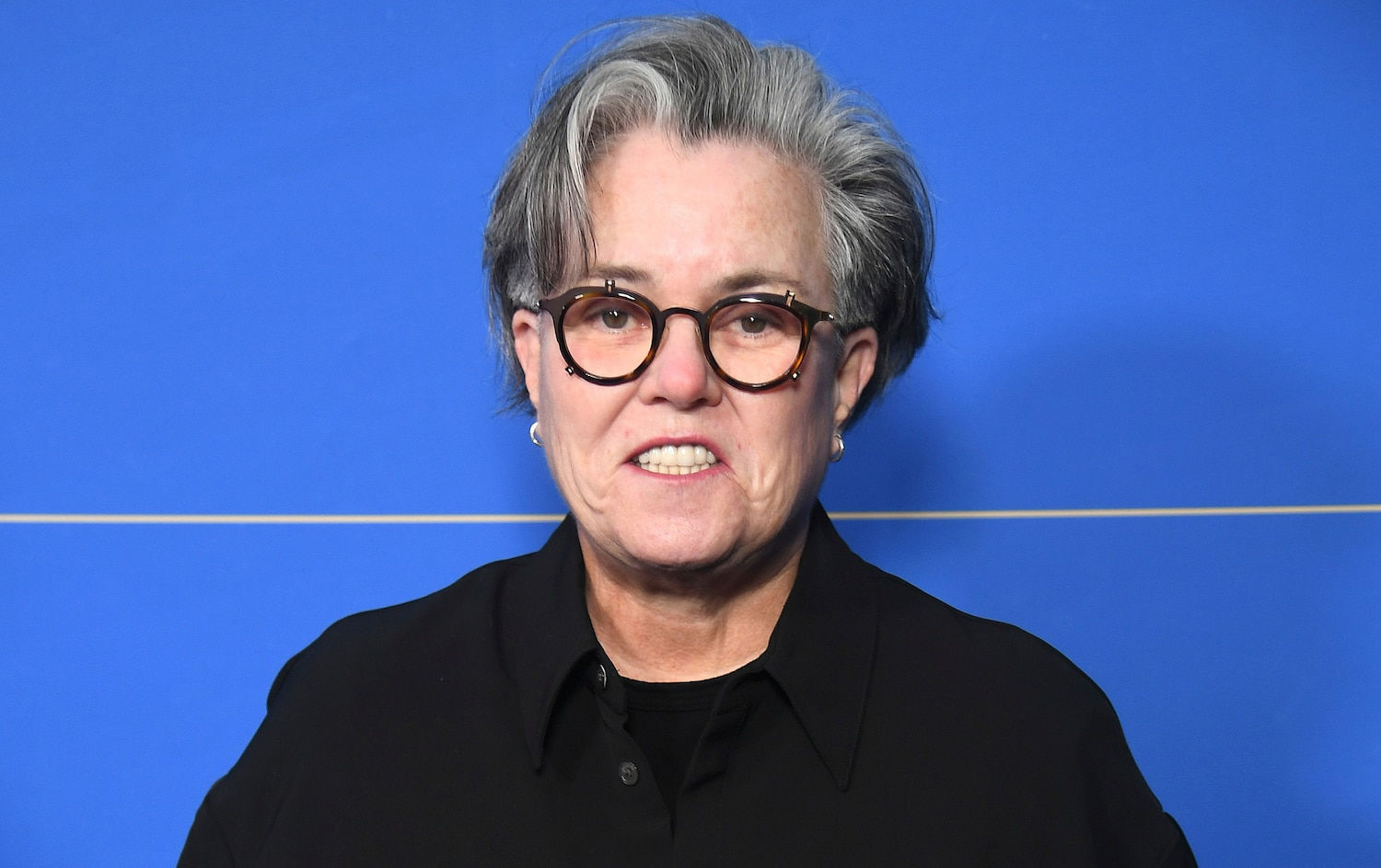 Rosie O'Donnell at press event with blue backdrop