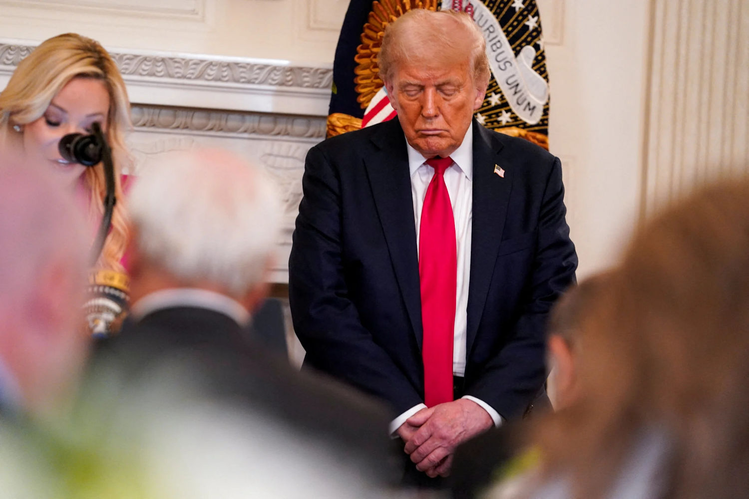 Donald Trump standing with eyes closed at White House prayer luncheon