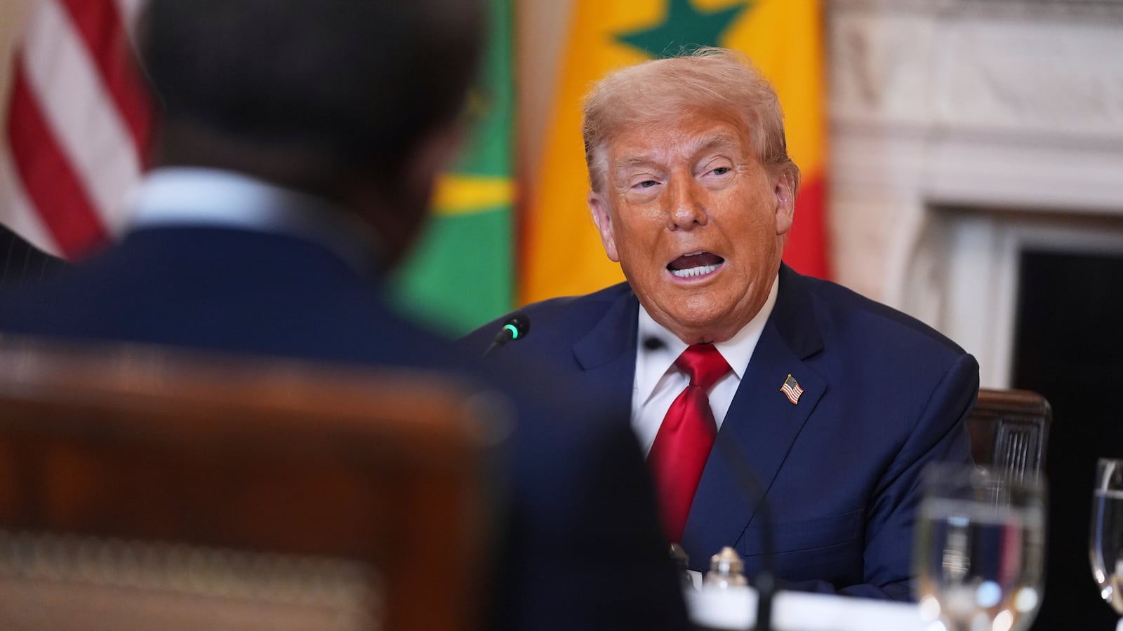 Donald Trump speaking with flags in background during press event