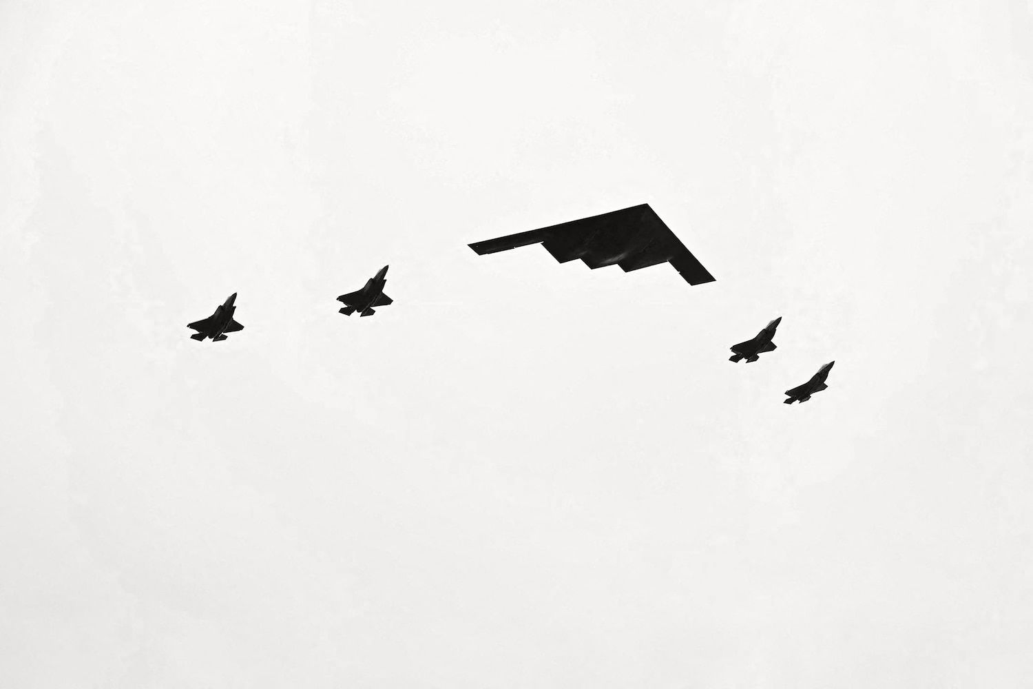 B-2 bomber and fighter jets fly over airbase during Trump and Putin arrival