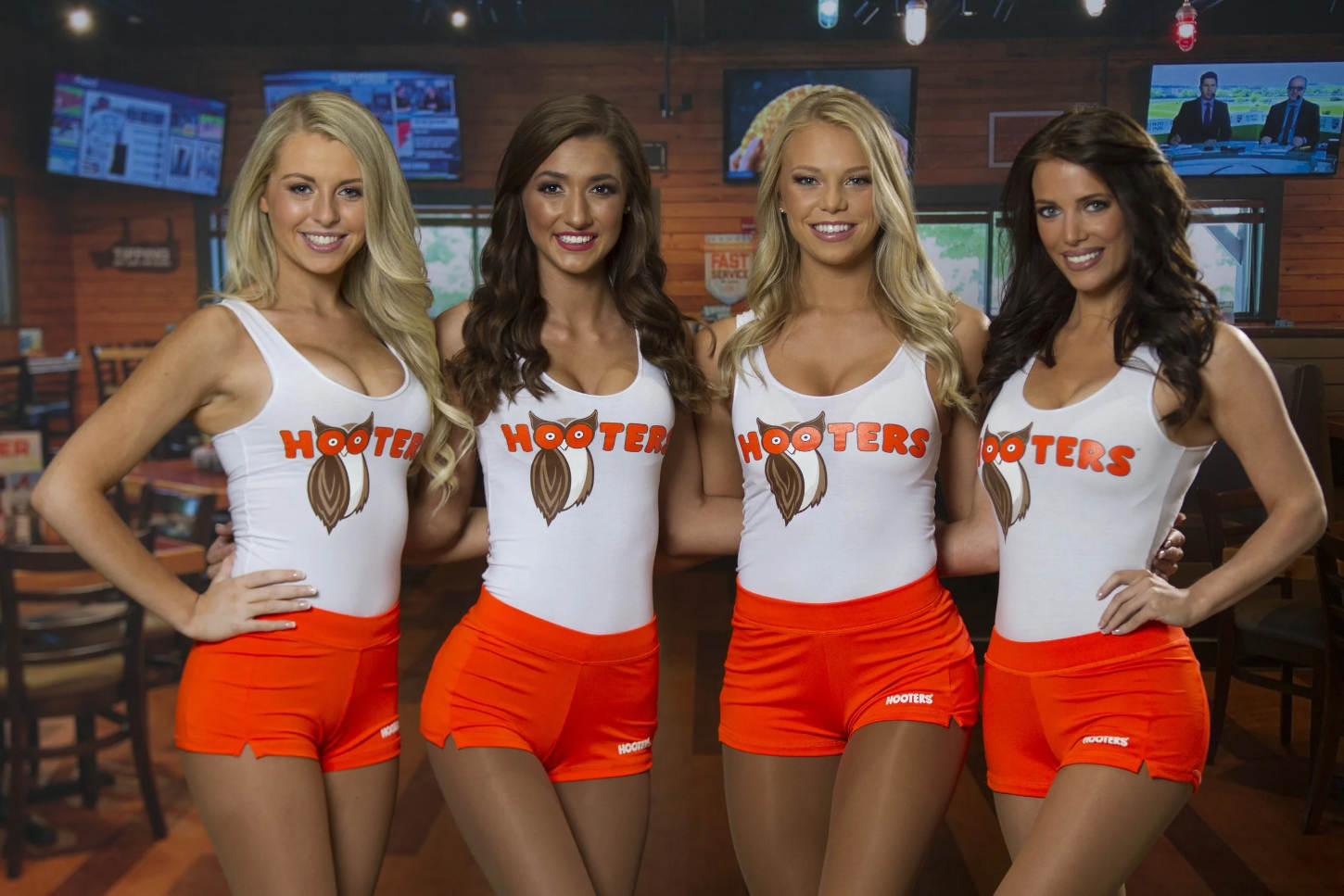 Hooters waitresses posing in front of restaurant interior