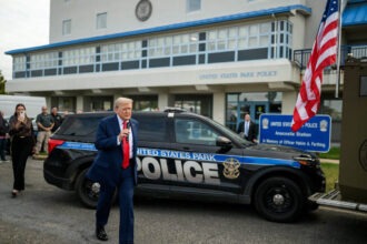 Donald Trump speaking outside United States Park Police station with microphone.