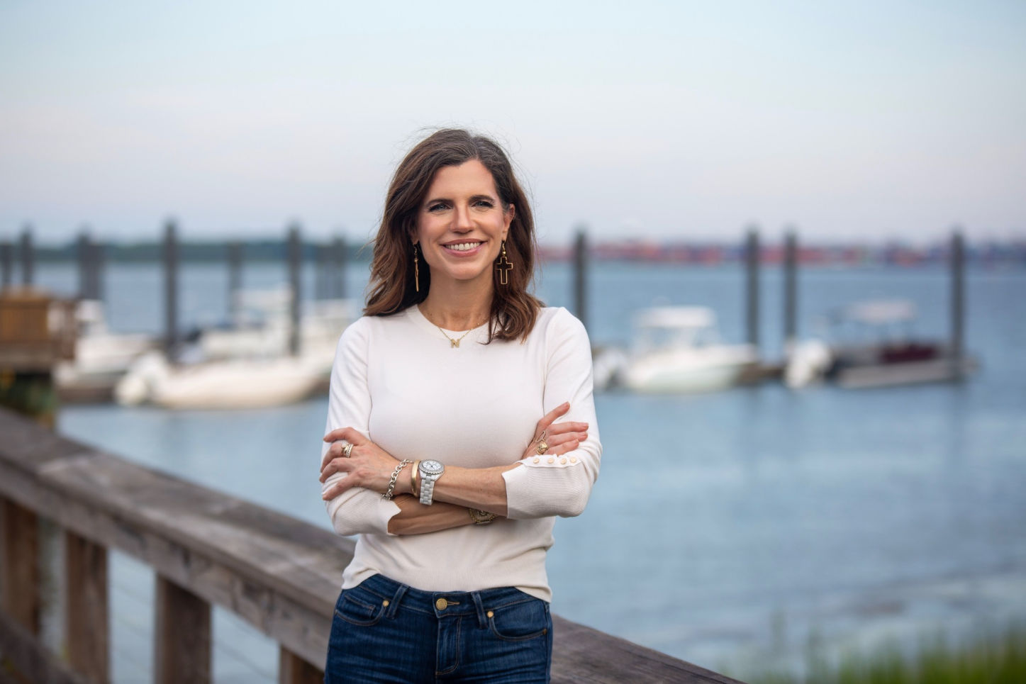 Nancy Mace stands near a dock smiling with arms crossed