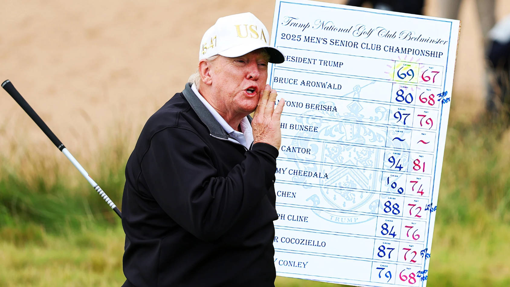 Trump holding golf club and scorecard at Bedminster championship