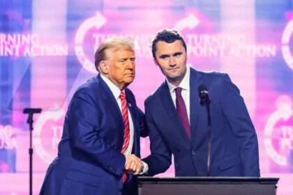 Donald Trump shakes hands with Charlie Kirk onstage at a Turning Point USA event