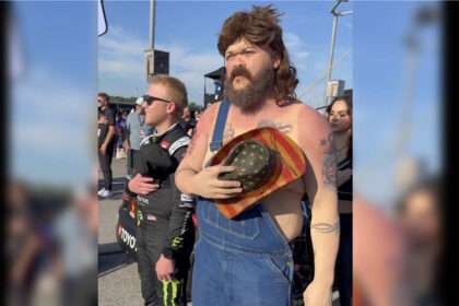 Comedian Druski in overalls and mullet disguise at NASCAR event