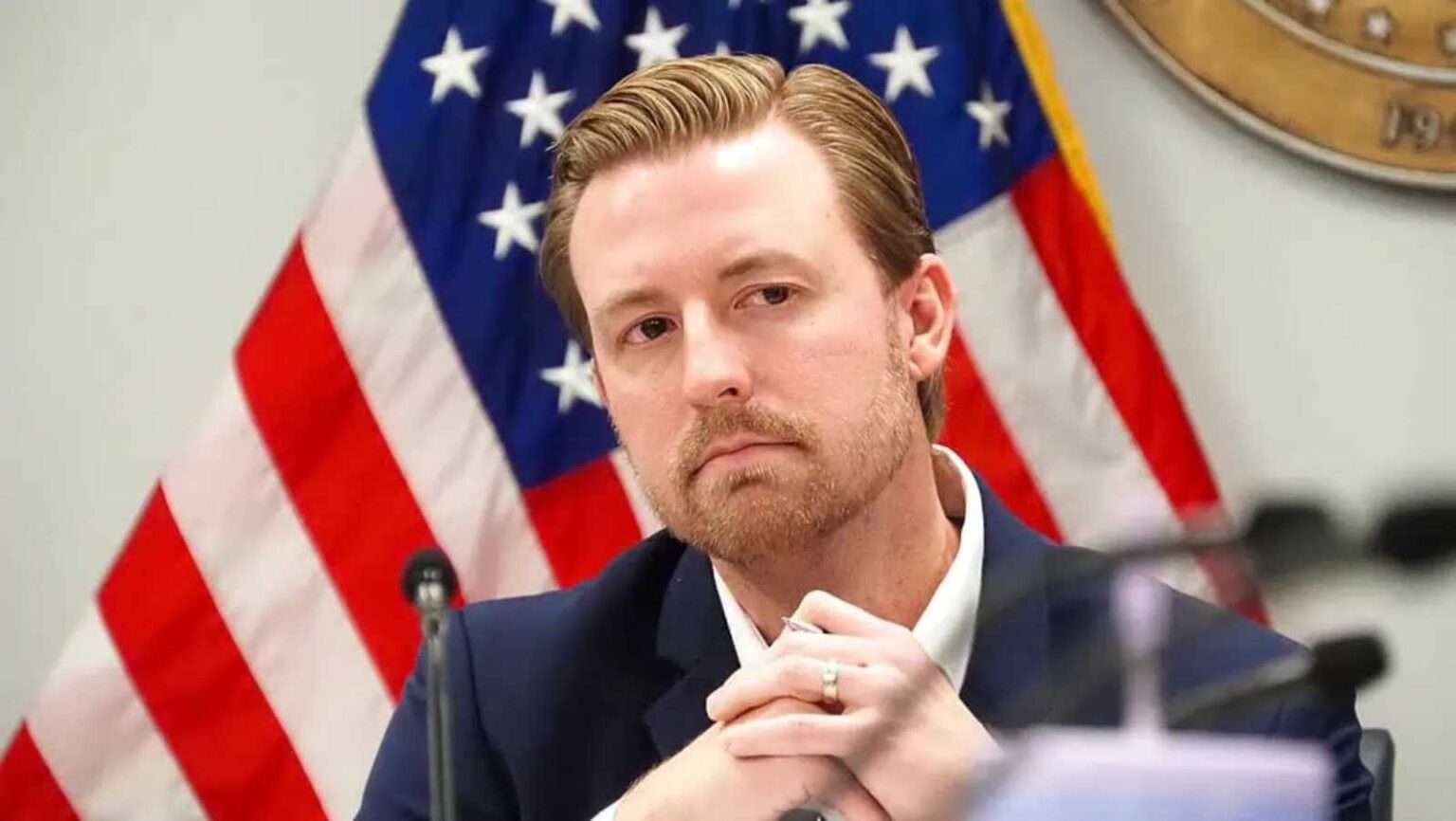 Oklahoma Superintendent Ryan Walters speaking in front of an American flag