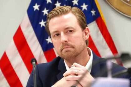 Oklahoma Superintendent Ryan Walters speaking in front of an American flag