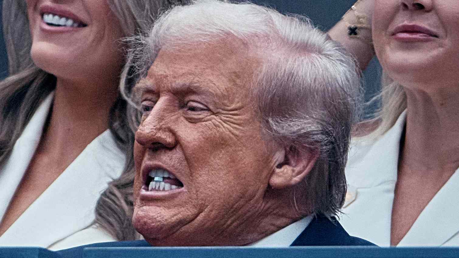 Donald Trump biting a small blue object during the U.S. Open men’s final.