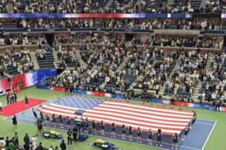Large American flag displayed on the court at the U.S. Open before a match.