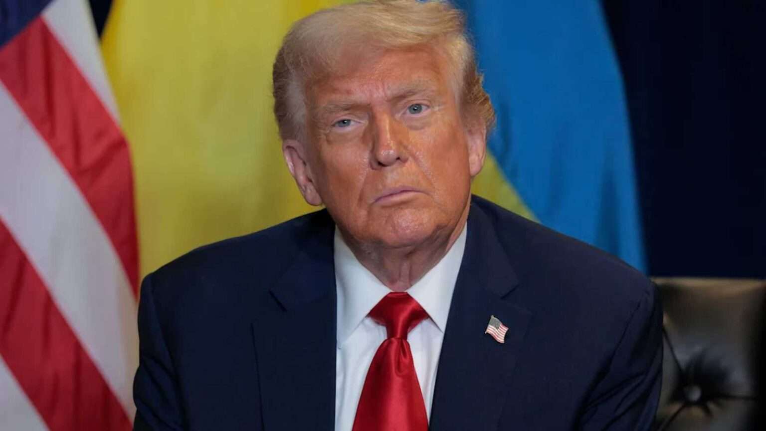 Donald Trump at press conference with American and Ukrainian flags behind him