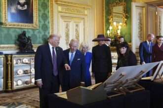 Donald Trump with King Charles III and Queen Camilla viewing royal items at Windsor Castle