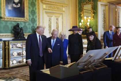 Donald Trump with King Charles III and Queen Camilla viewing royal items at Windsor Castle