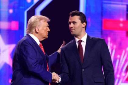 Donald Trump shaking hands with Charlie Kirk on stage