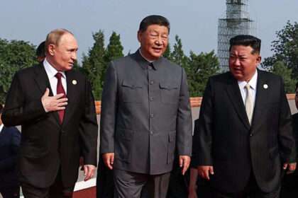 Xi Jinping, Vladimir Putin, and Kim Jong Un talking at a public event in Beijing.