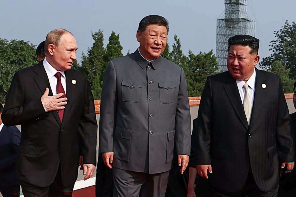Xi Jinping, Vladimir Putin, and Kim Jong Un talking at a public event in Beijing.