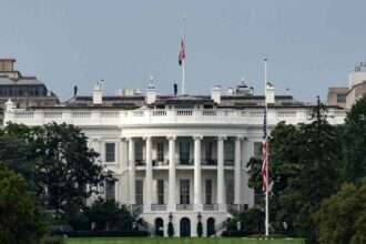 The White House with U.S. flags flying at half-mast