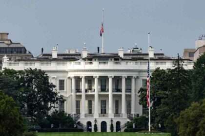 The White House with U.S. flags flying at half-mast