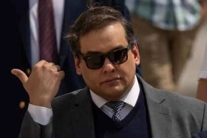 Former congressman George Santos wearing sunglasses after early release