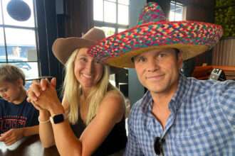 Pete Hegseth and a woman wearing sombreros smiling at a restaurant table