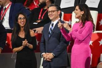 Lauren Boebert, Mike Johnson, and Nancy Mace standing together at a political event, smiling and talking in the audience.