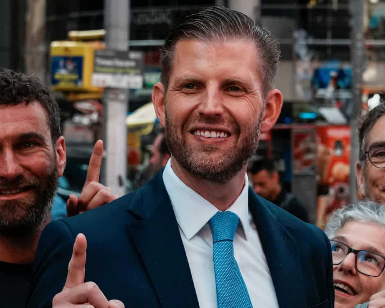 Eric Trump smiling at an outdoor public appearance.