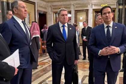 Diplomatic officials standing together during a meeting in an ornate hall.