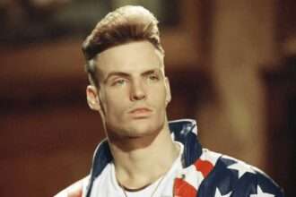 Vanilla Ice wearing a stars and stripes jacket in a promotional portrait.